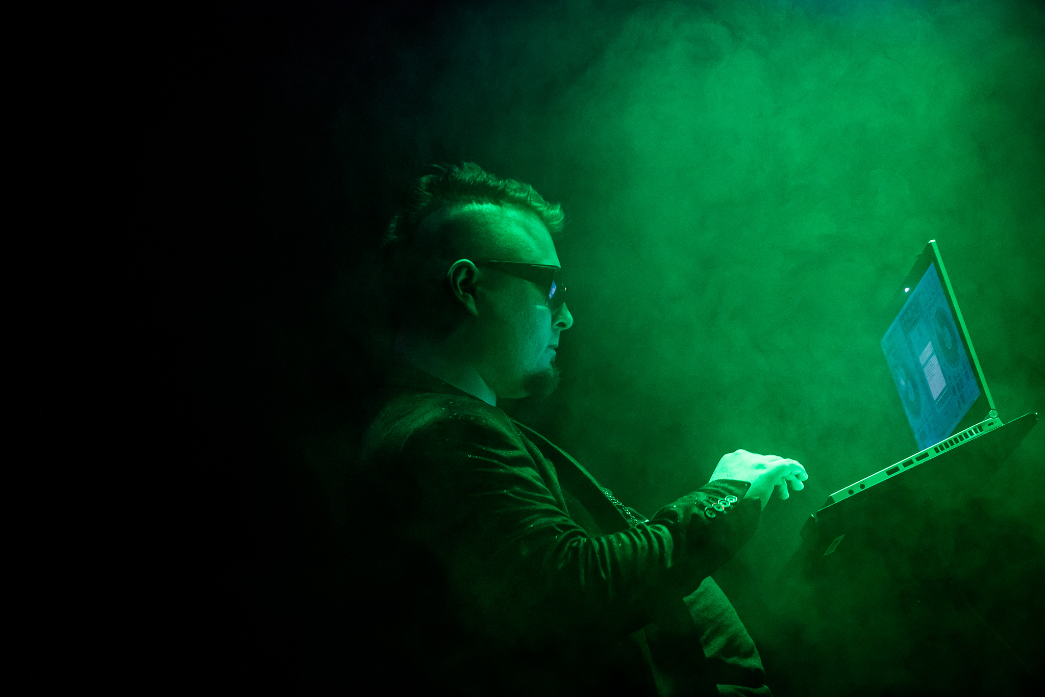 A green, fog-filled moment of Mike working on the DJ laptop.
