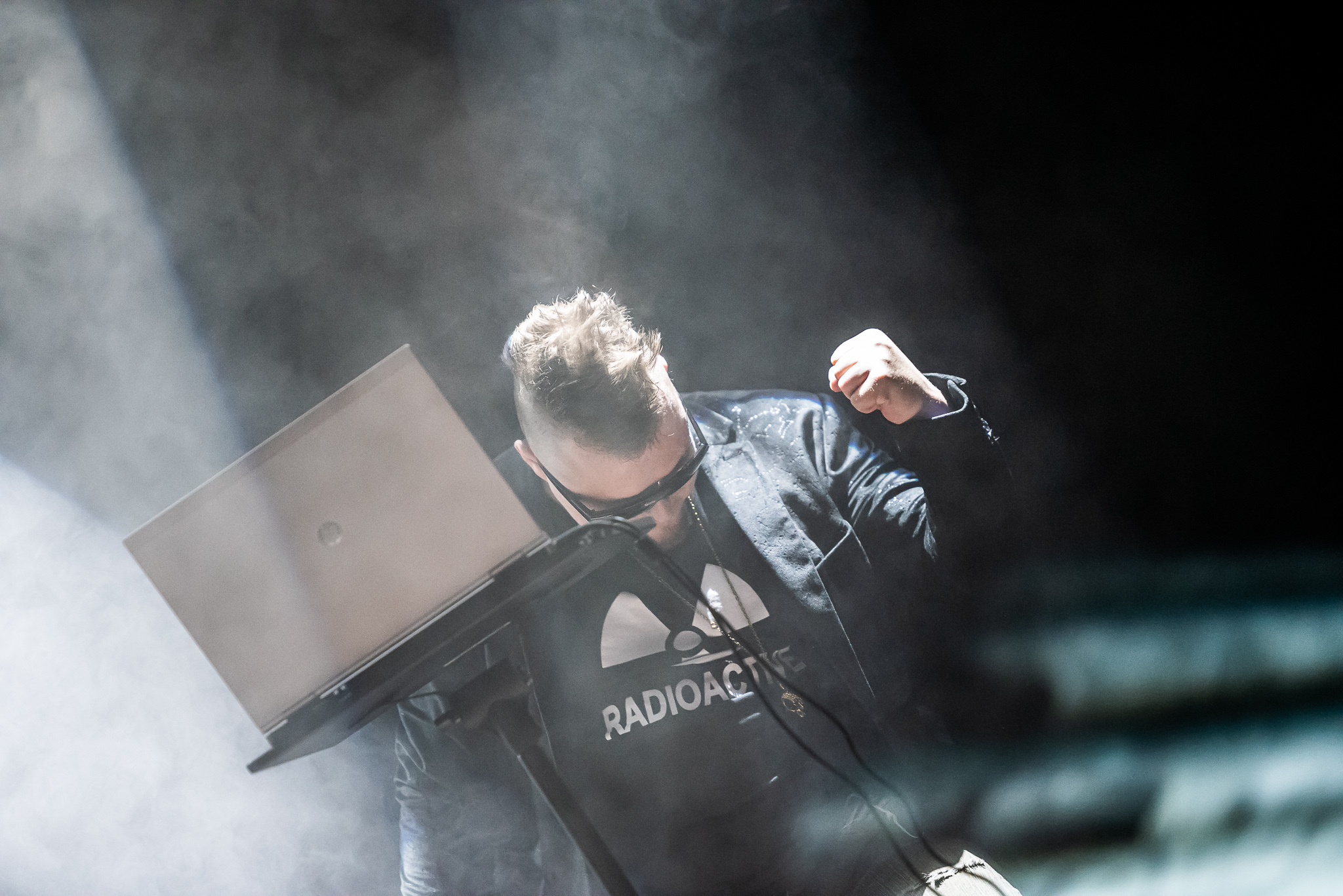 Mike Midas vibing with a classic oldschool gig laptop. Wearing his usual golden alien skull pendant.